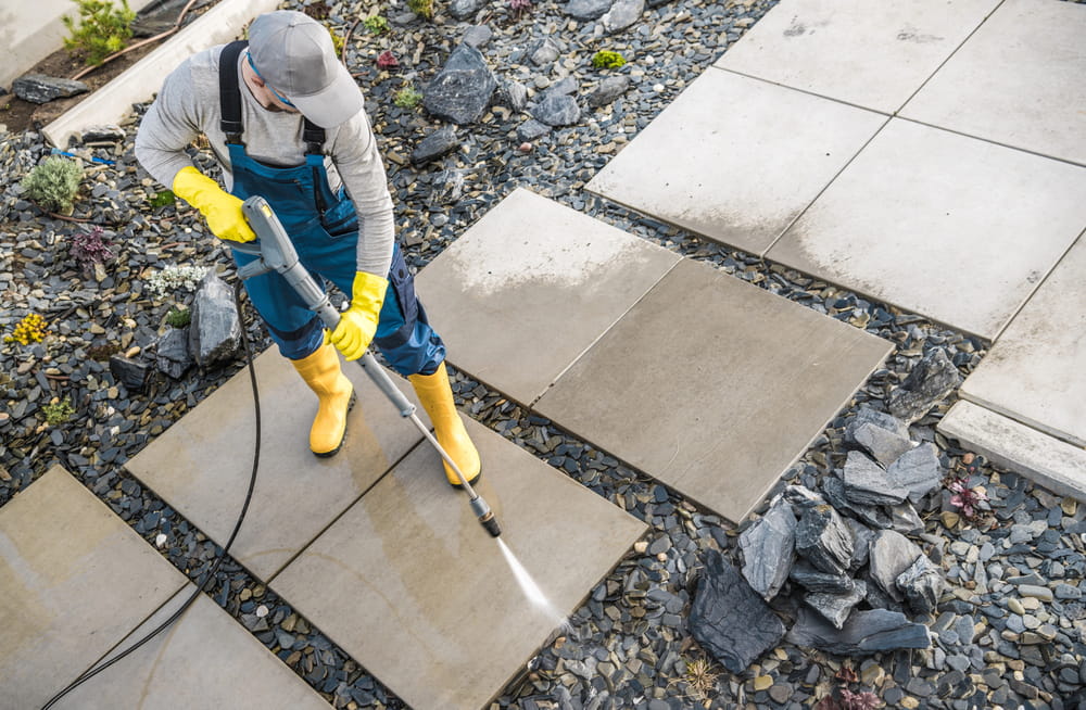 a man washing his patio with a professional power washing machine