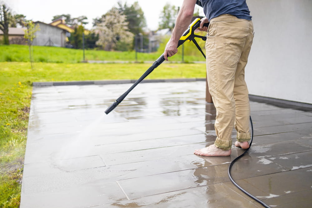 High water pressure cleaner on wet concrete terrace surface